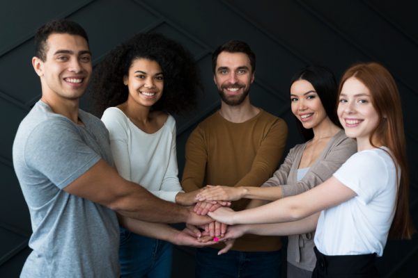 Grupo de jovens felizes em grupo praticando a inteligência emocional